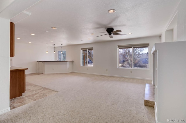 unfurnished living room featuring recessed lighting, light colored carpet, ceiling fan, and a textured ceiling