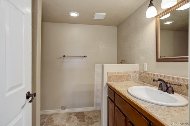 bathroom featuring visible vents, baseboards, and vanity