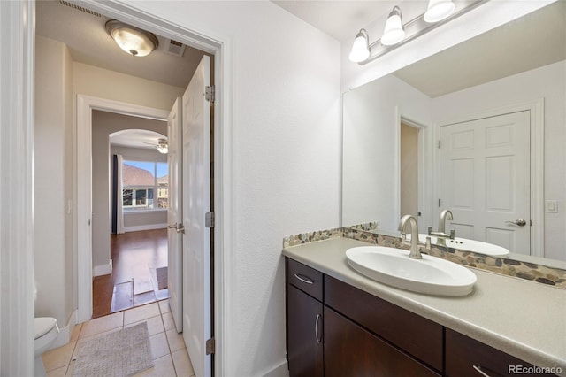 bathroom featuring visible vents, toilet, vanity, baseboards, and tile patterned floors