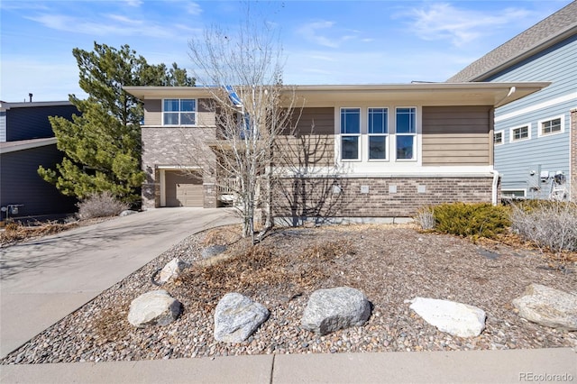 view of front of house featuring driveway, an attached garage, and brick siding