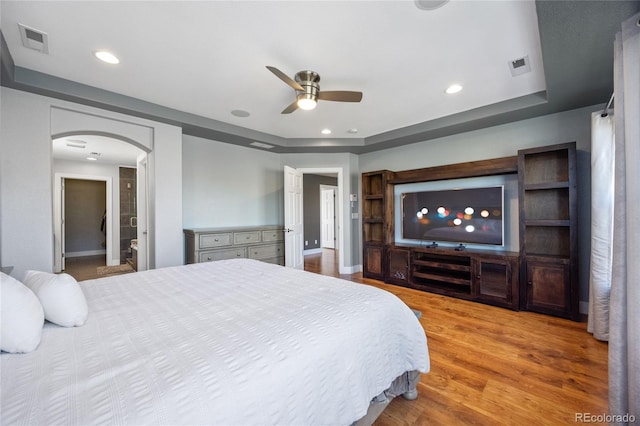 bedroom featuring arched walkways, wood finished floors, visible vents, and recessed lighting