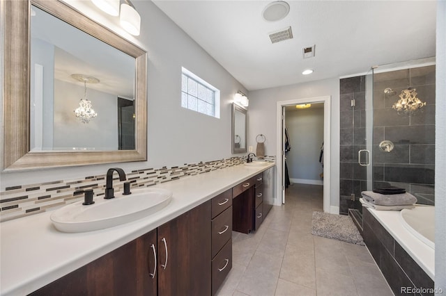 full bathroom with visible vents, a sink, a shower stall, and decorative backsplash