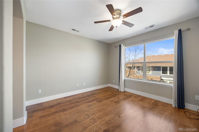 unfurnished room with ceiling fan, wood finished floors, visible vents, and baseboards