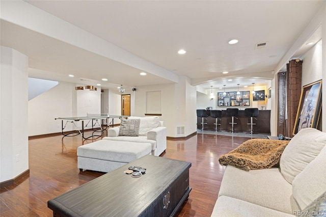 living area featuring a dry bar, baseboards, wood finished floors, and recessed lighting