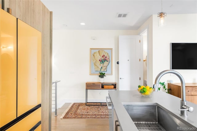 1333 Elati St Unit 1, Denver, CO 80204 - kitchen with visible vents, pendant lighting, a sink, baseboards, and light wood finished floors