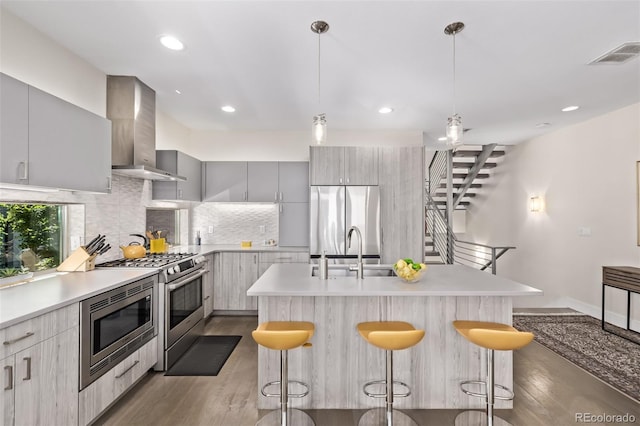 1333 Elati St Unit 1, Denver, CO 80204 - kitchen with wall chimney exhaust hood, stainless steel appliances, a breakfast bar area, dark wood-style flooring, and recessed lighting