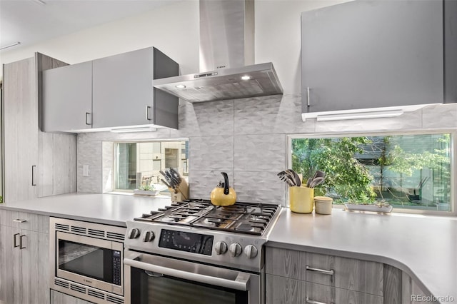 1333 Elati St Unit 1, Denver, CO 80204 - kitchen featuring appliances with stainless steel finishes, wall chimney range hood, decorative backsplash, light countertops, and modern cabinets