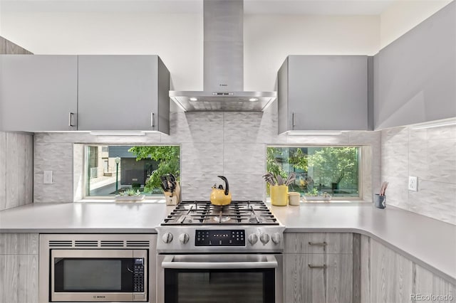 1333 Elati St Unit 1, Denver, CO 80204 - kitchen featuring wall chimney range hood, appliances with stainless steel finishes, light countertops, and modern cabinets
