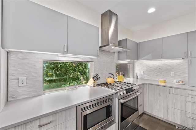 1333 Elati St Unit 1, Denver, CO 80204 - kitchen featuring wall chimney exhaust hood, appliances with stainless steel finishes, modern cabinets, light countertops, and backsplash