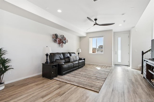 living room with ceiling fan and light hardwood / wood-style flooring