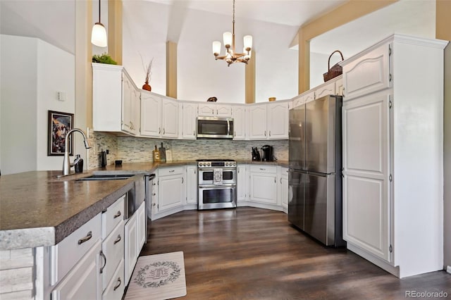 5465 Broadmoor Bliff Dr, Colorado Springs, CO 80904 - kitchen featuring stainless steel appliances, a chandelier, dark wood-type flooring, tasteful backsplash, and a high ceiling