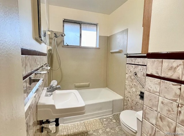 5671 E 60th St, Commerce City, CO 80022 - bathroom featuring tile walls and shower / tub combination