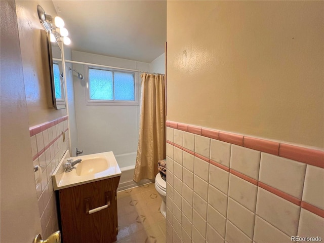 5671 E 60th St, Commerce City, CO 80022 - full bath with vanity, shower / bath combo with shower curtain, tile walls, and a wainscoted wall