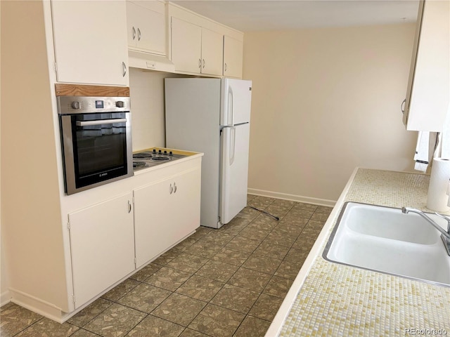 5671 E 60th St, Commerce City, CO 80022 - kitchen featuring stainless steel oven, freestanding refrigerator, light countertops, white cabinets, and electric stovetop