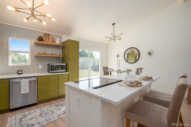 kitchen with stainless steel appliances, a breakfast bar, a notable chandelier, and green cabinetry