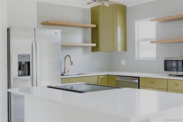 kitchen featuring sink, refrigerator with ice dispenser, green cabinets, backsplash, and stainless steel dishwasher