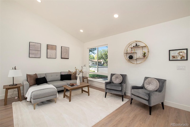 living room with light hardwood / wood-style floors and vaulted ceiling