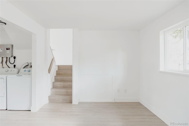 staircase featuring wood-type flooring, electric panel, and washer and dryer