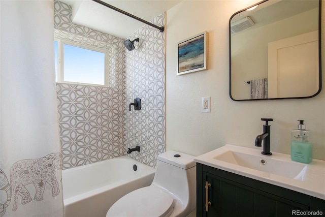 full bathroom featuring vanity, tiled shower / bath combo, and toilet