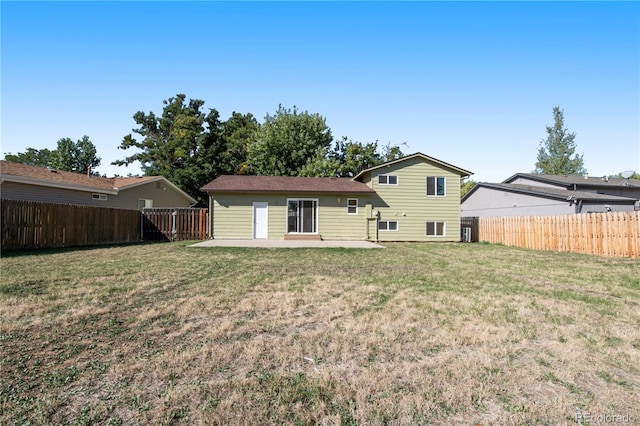 back of property with a yard and a patio area