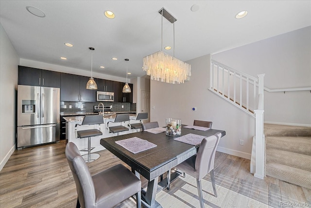 21392 E Stroll Ave, Parker, CO 80138 - dining room with a chandelier, recessed lighting, stairway, and light wood-style flooring