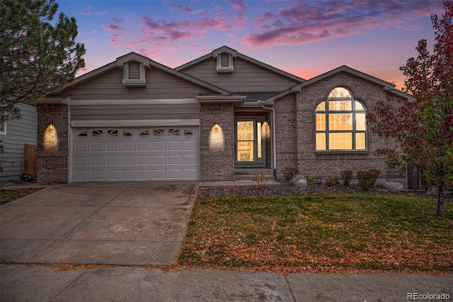 view of front of property with a garage and a lawn