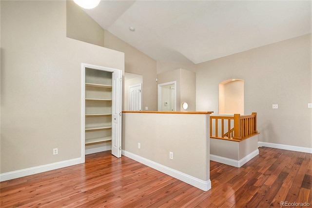 spare room featuring hardwood / wood-style floors and vaulted ceiling