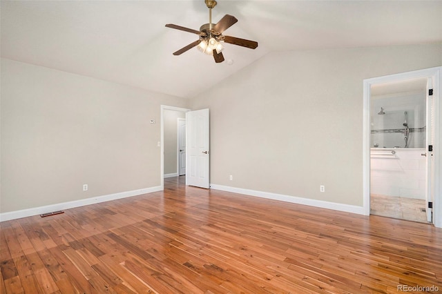 unfurnished bedroom featuring connected bathroom, hardwood / wood-style floors, vaulted ceiling, and ceiling fan