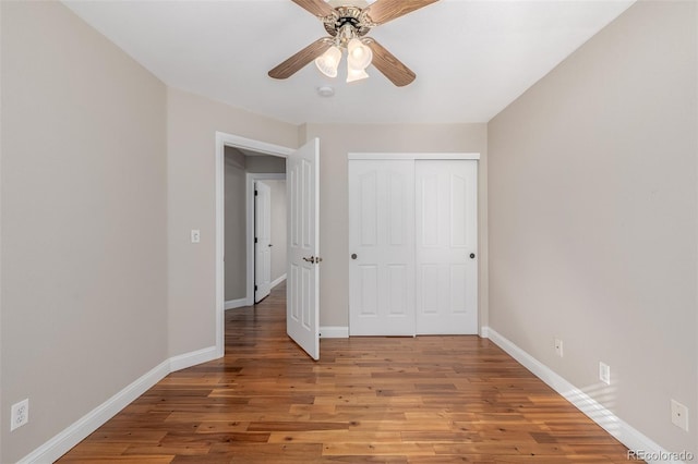 unfurnished bedroom with a closet, hardwood / wood-style flooring, and ceiling fan