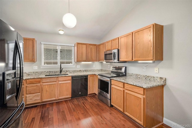 kitchen featuring appliances with stainless steel finishes, pendant lighting, sink, dark wood-type flooring, and lofted ceiling