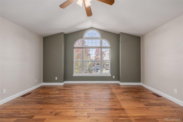 empty room with ceiling fan, lofted ceiling, and light hardwood / wood-style floors