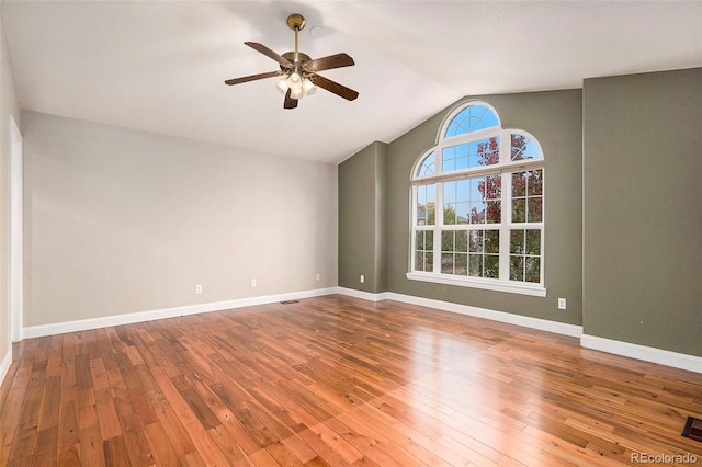 empty room with hardwood / wood-style floors, ceiling fan, and lofted ceiling