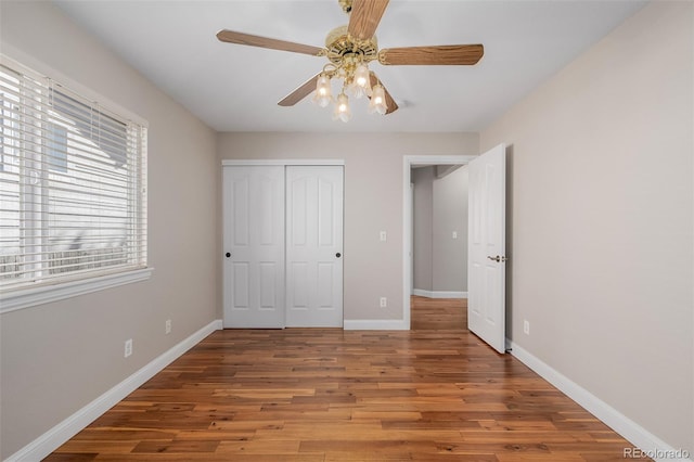 unfurnished bedroom featuring hardwood / wood-style floors, ceiling fan, and a closet