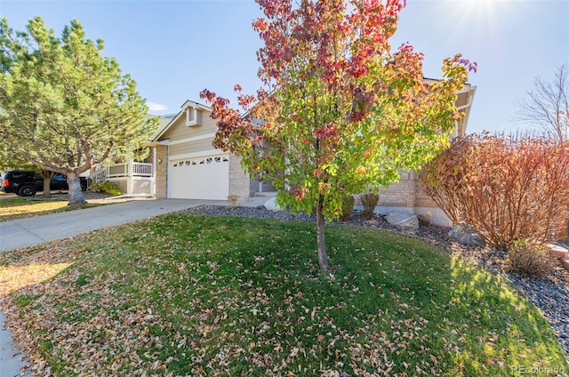 view of property hidden behind natural elements featuring a garage and a front yard