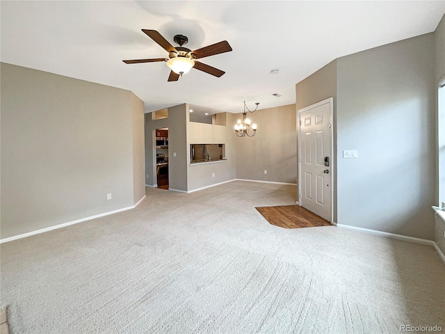 unfurnished living room featuring carpet flooring and ceiling fan with notable chandelier