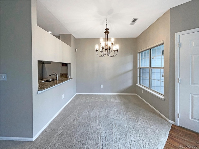 unfurnished dining area with sink and a chandelier