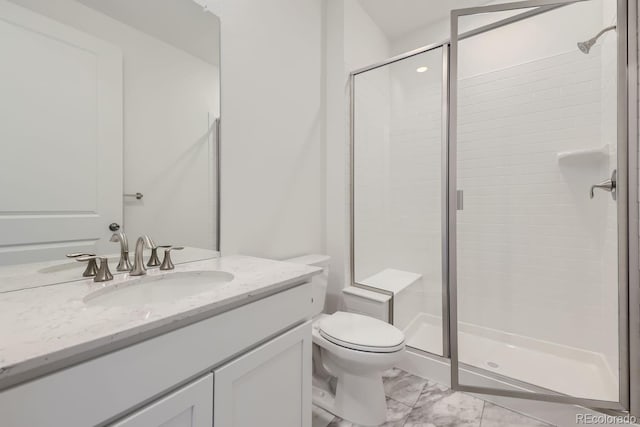 bathroom featuring toilet, vanity, and a shower with shower door