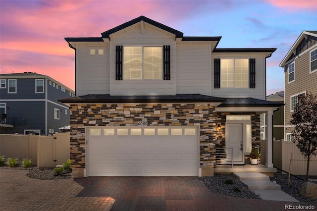 4060 N Rome St, Aurora, CO 80019 - view of front of property featuring a garage, stone siding, and decorative driveway