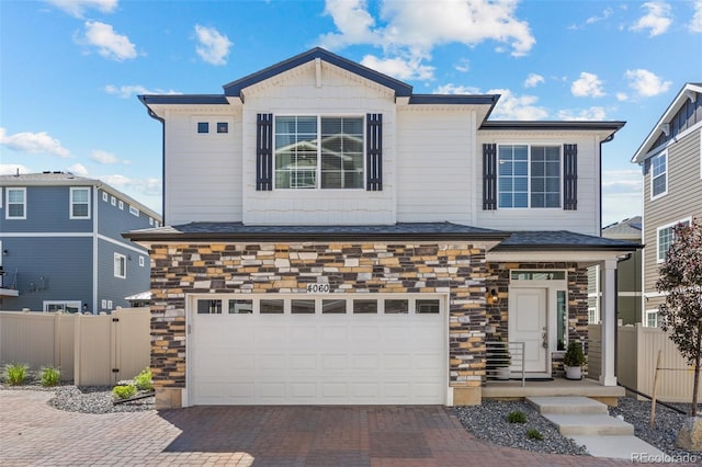 4060 N Rome St, Aurora, CO 80019 - view of front of home featuring an attached garage, stone siding, and decorative driveway
