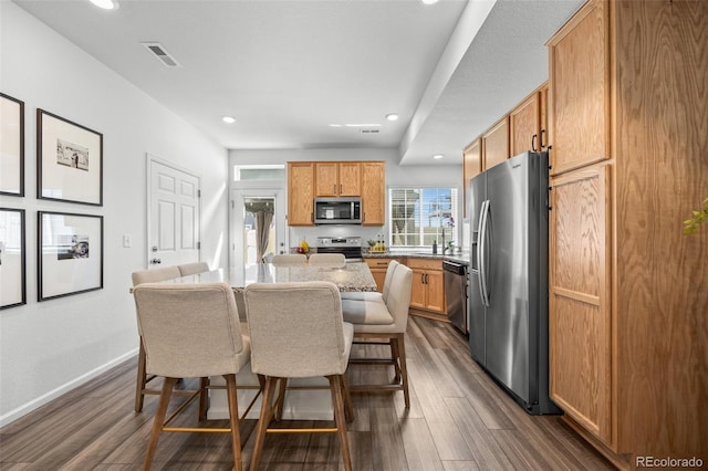 4060 N Rome St, Aurora, CO 80019 - kitchen featuring stainless steel appliances, a breakfast bar, dark wood finished floors, a center island, and recessed lighting