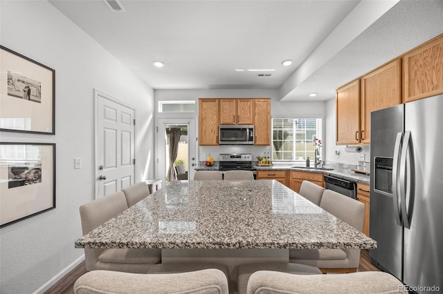 4060 N Rome St, Aurora, CO 80019 - kitchen with stainless steel appliances, a sink, a kitchen breakfast bar, dark wood-style floors, and recessed lighting