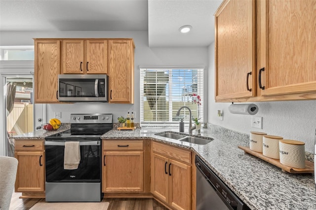 4060 N Rome St, Aurora, CO 80019 - kitchen with stainless steel appliances, a sink, light stone counters, and wood finished floors