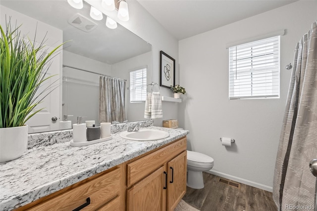 4060 N Rome St, Aurora, CO 80019 - bathroom with vanity, wood finished floors, toilet, baseboards, and a shower with shower curtain