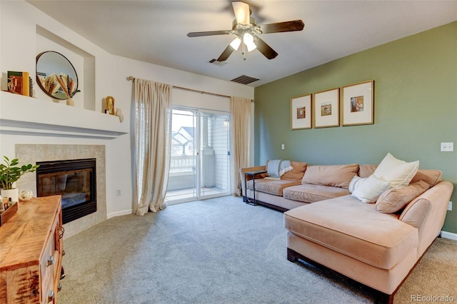 carpeted living area featuring a tiled fireplace, visible vents, and a ceiling fan