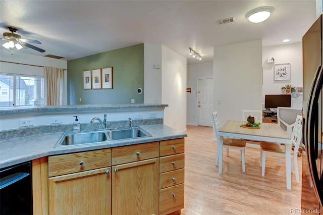 kitchen featuring visible vents, light wood finished floors, ceiling fan, a sink, and black appliances