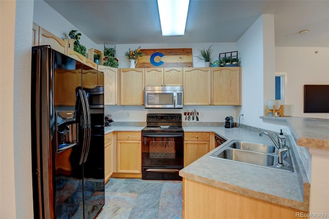 kitchen featuring light brown cabinets, light countertops, a peninsula, black appliances, and a sink