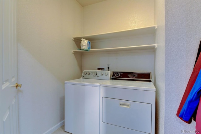 laundry area with laundry area, baseboards, and washing machine and clothes dryer