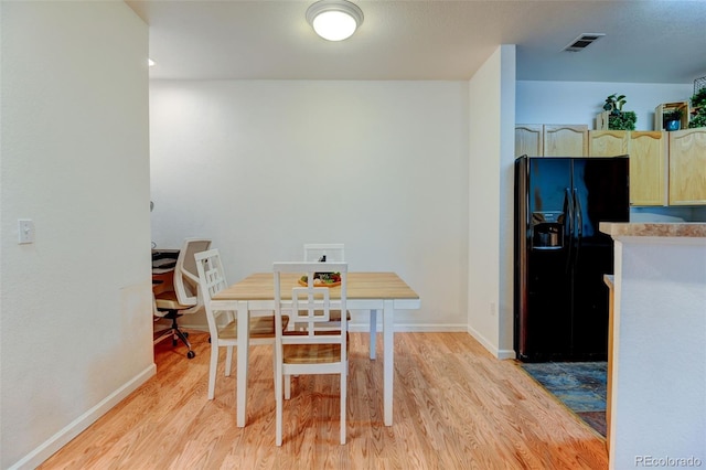 dining room with baseboards, visible vents, and light wood finished floors