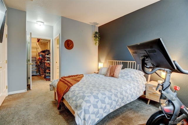 carpeted bedroom featuring a closet, baseboards, and a spacious closet