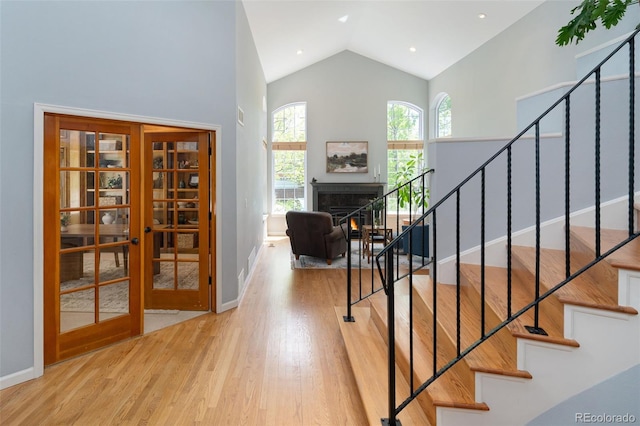 2345 Spotswood Pl, Boulder, CO 80304 - staircase with wood finished floors, french doors, baseboards, a warm lit fireplace, and high vaulted ceiling